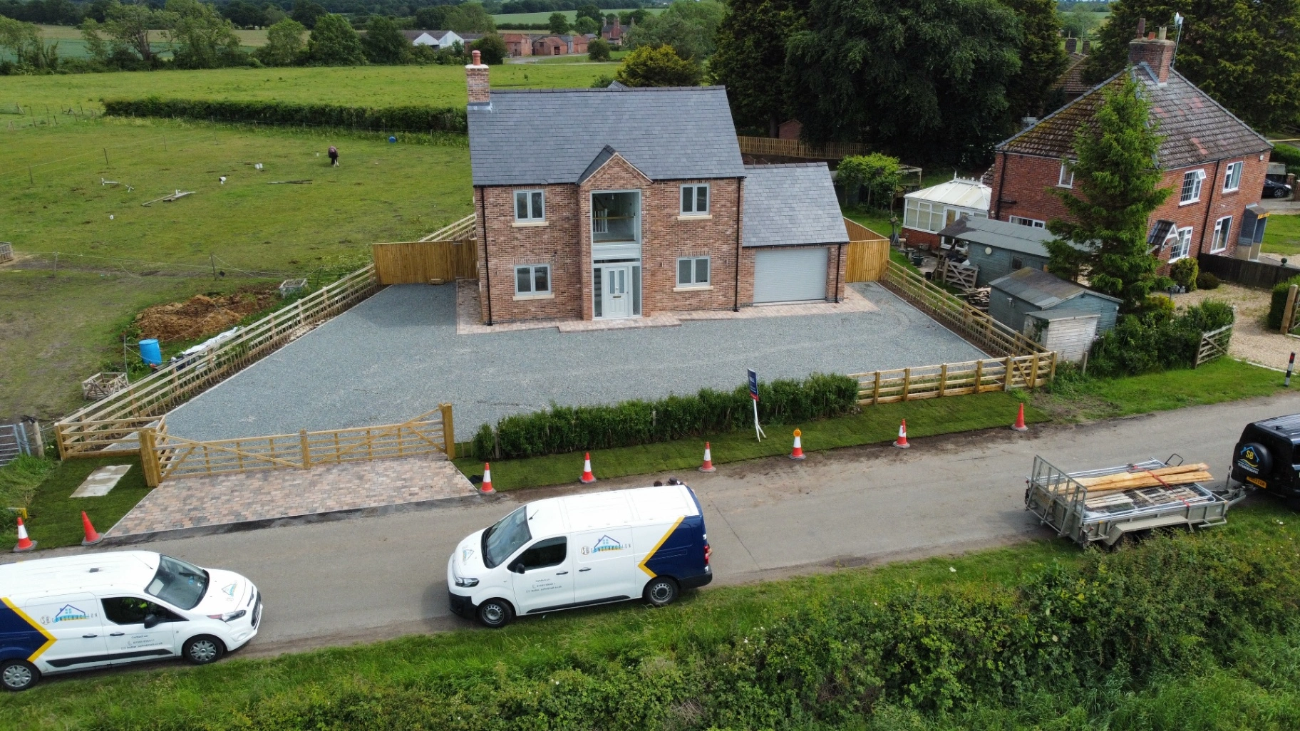 Wide gravel driveway with block paved entrance apron.