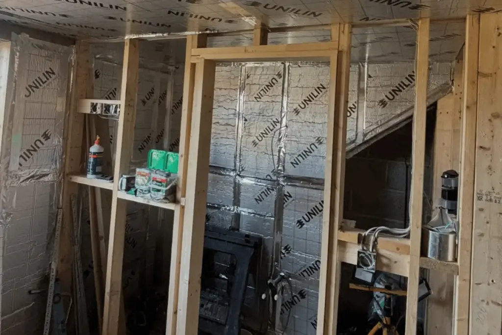 Builder working inside the loft as insulation and boarding progress continues in Louth project