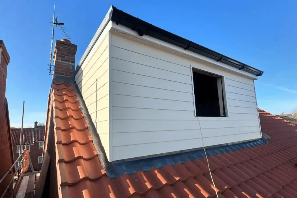 Builder working inside the loft as insulation and boarding progress continues in Louth project